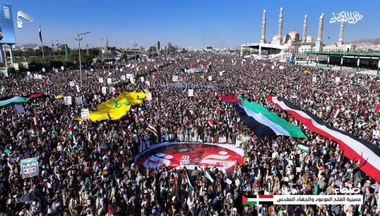 Crowds in Sana'a, the Houthi-controlled capital of Yemen, hold aloft Yemeni and Palestinian flags at a protest against Western missile strikes. The bombings were carried out in retaliation for attacks on shipping by Houthi forces. Image: Wikimedia Commons Image:Crowds in Sana'a, the Houthi-controlled capital of Yemen, hold aloft Yemeni and Palestinian flags at a protest against Western missile strikes. The bombings were carried out in retaliation for attacks on shipping by Houthi forces. Image: Wikimedia Commons