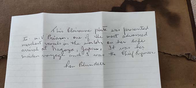 A note from the late Ron Blundell detailing the gift of a wall plaque of Nagoya Castle. The note reads: 'This cloisonne plate was presented to the MV Priam, one of the most advanced merchant vessels in the world, on her safe arrival at Nagoya, Japan. It was her maiden voyage and I was her chief engineer.' Image: Keith Blundell Image:A note from the late Ron Blundell detailing the gift of a wall plaque of Nagoya Castle. The note reads: 'This cloisonne plate was presented to the MV Priam, one of the most advanced merchant vessels in the world, on her safe arrival at Nagoya, Japan. It was her maiden voyage and I was her chief engineer.' Image: Keith Blundell